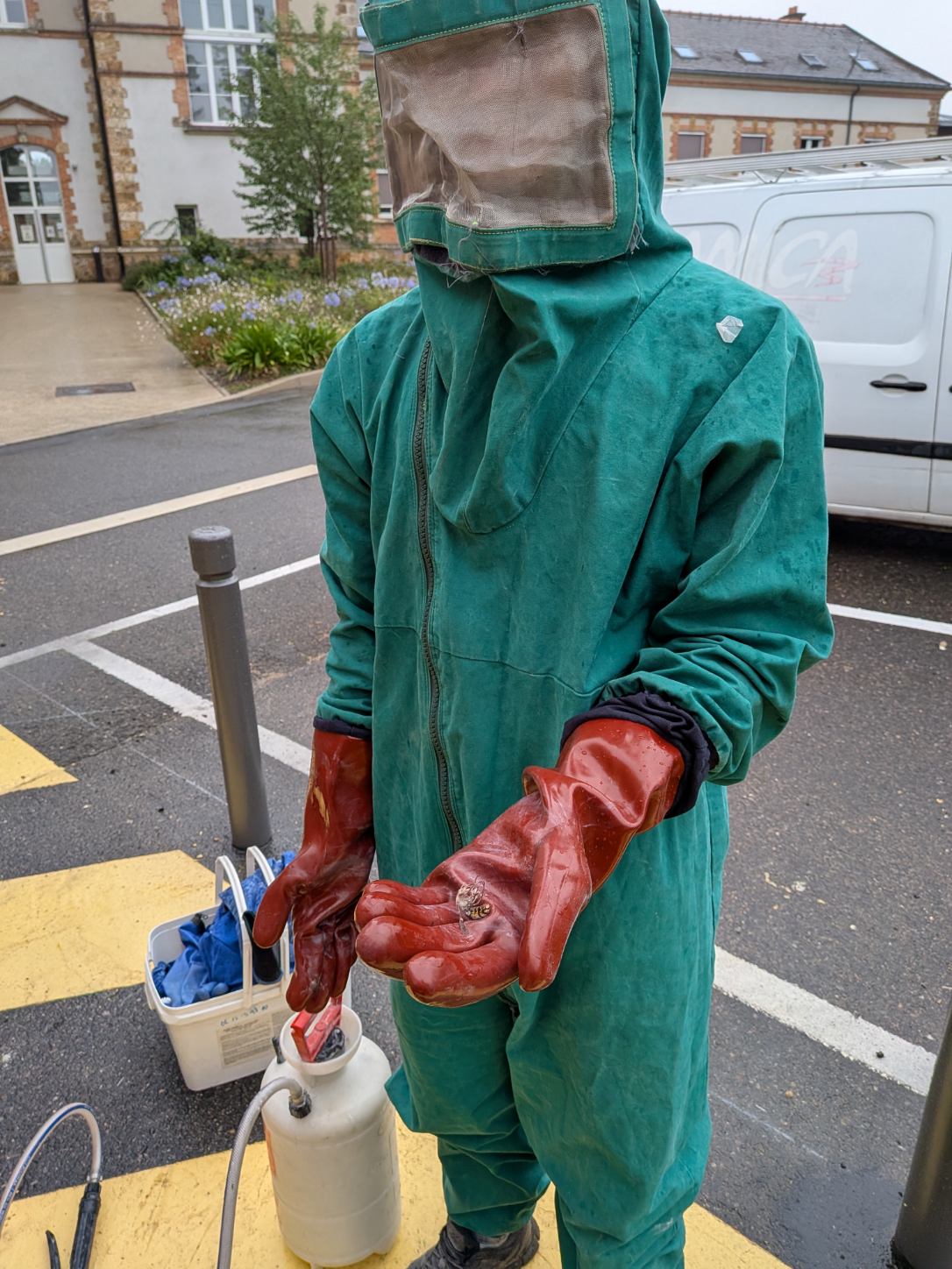 Technicien en dératisation équipé d'une combinaison et d'un pulvérisateur professionnel